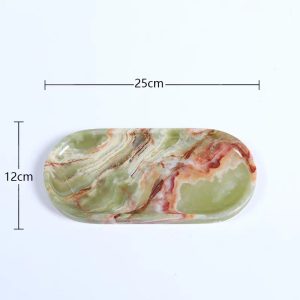 Elevate your space with this handcrafted oval tray, meticulously carved from premium antique green jade. Measuring 25 cm in length and 12 cm in width, this elegant piece showcases a mesmerizing blend of natural green, red, and white veins, creating a unique artistic texture that resembles a painting by nature itself. Each delicate swirl tells a story of time, exuding timeless charm and sophistication. Why Choose This Jade Tray? ✔ Luxurious Material – Made from natural jade stone, known for its durability and exquisite beauty. ✔ Versatile Use – Perfect as a decorative display tray or a functional organizer for jewelry, tea sets, or perfumes. ✔ Elegant Aesthetic – The antique jade’s rich hues add a touch of refinement to any home or office. Customization Options Available At SINO TOPSTONE, we specialize in custom jade and marble trays, offering a variety of materials including: White Jade (Pure & Serene) Blue Jade (Tranquil & Sophisticated) Pink Jade (Delicate & Romantic) Classic Green Jade (Timeless & Noble) Premium Marble (Luxurious & Durable) Whether you seek a personalized gift or a statement decor piece, our handmade stone trays are designed to impress. Enhance Your Décor with Nature’s Artistry – Explore Our Jade Collection Today!